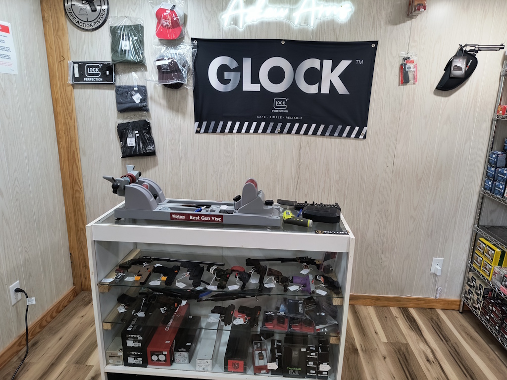 Askew Arms display rack showcasing handguns and scopes