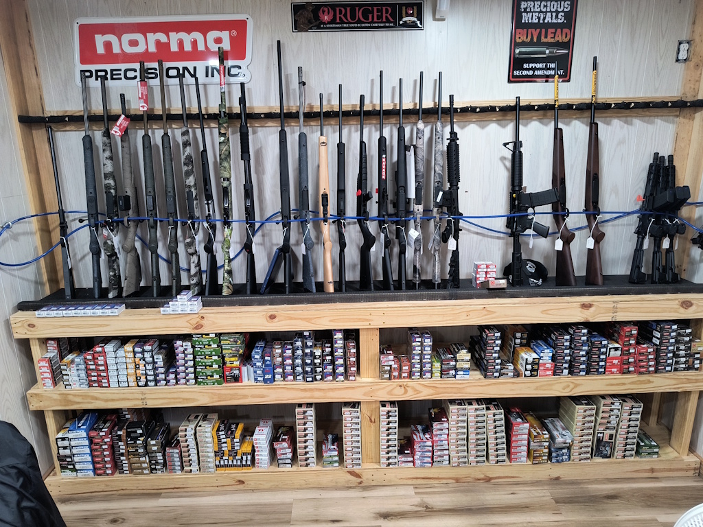 Askew Arms display rack showcasing rifles and ammunition